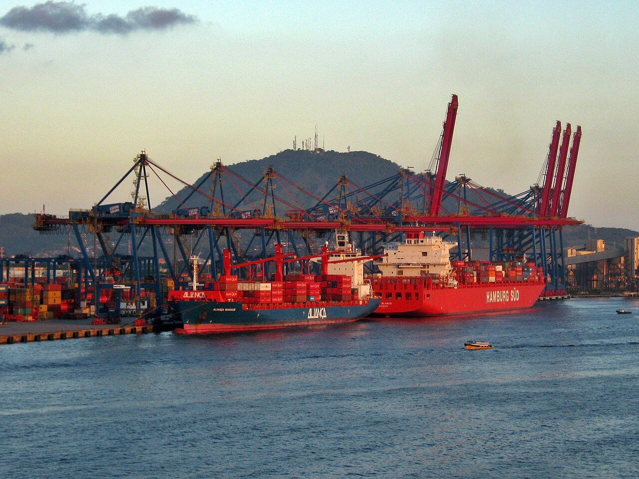 Navios porta-contêineres atracados sob guindastes no cais do Porto de Santos
