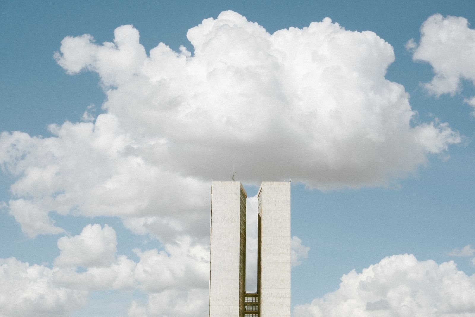 Torres do Congresso Nacional em Brasília sob céu com nuvens