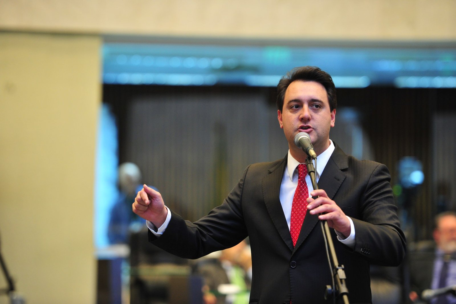 O governador do Paraná, Ratinho Junior, discursa ao microfone em tribuna
