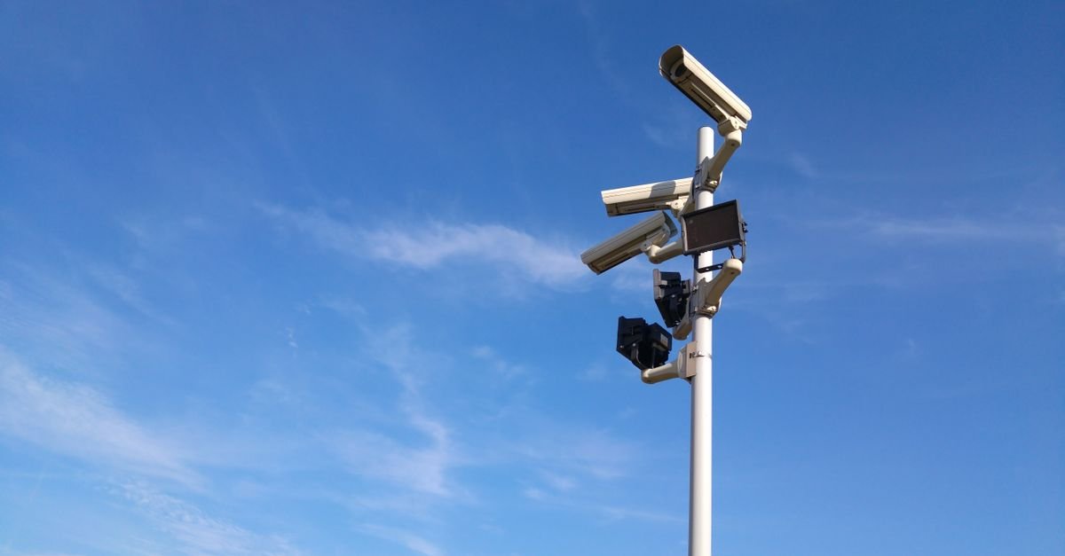 Poste com câmeras de monitoramento urbano contra o céu azul