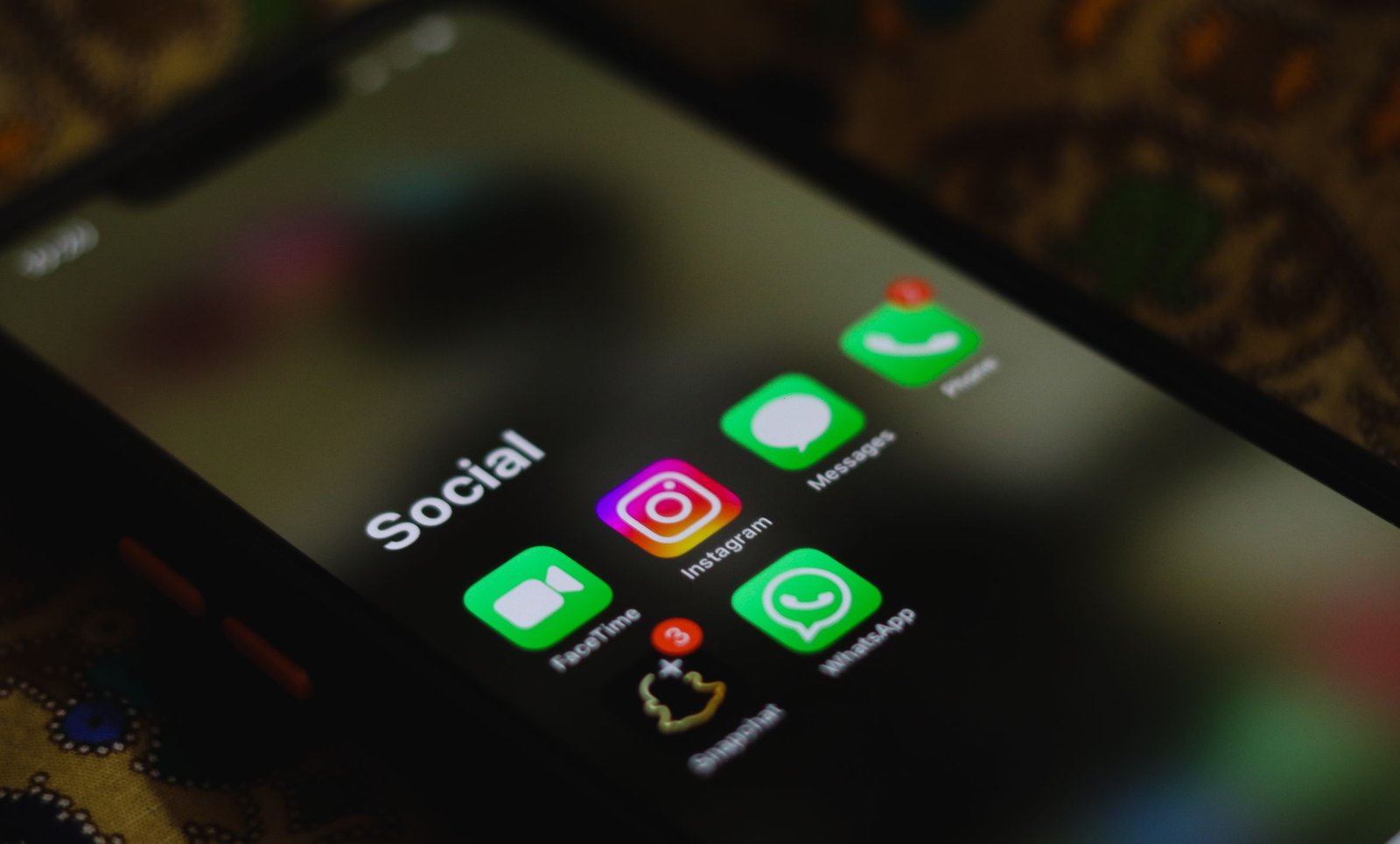 Tela de smartphone com ícones de aplicativos de redes sociais, incluindo Instagram e WhatsApp