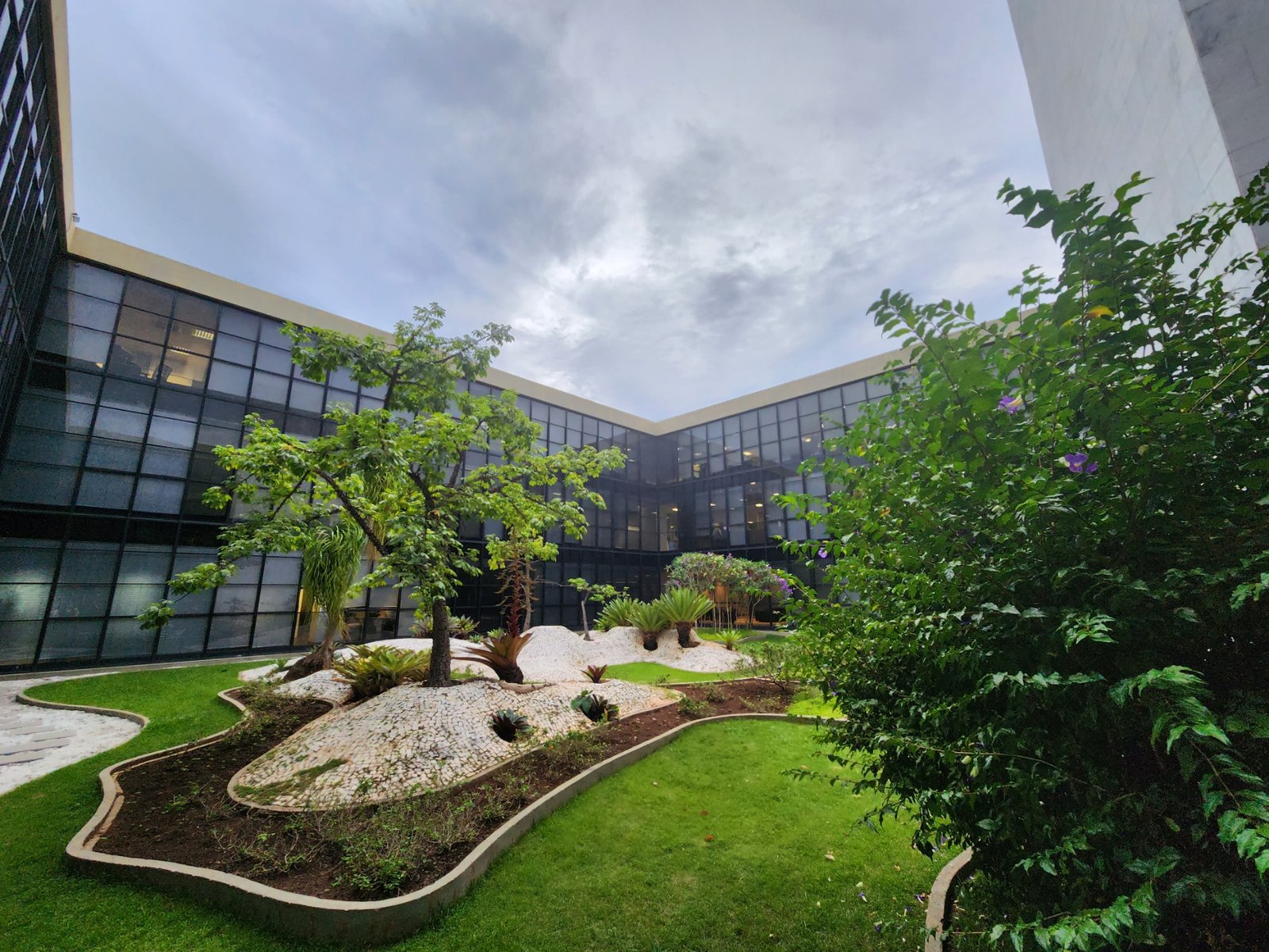 Jardim interno do edifício-sede do Tribunal de Contas da União, em Brasília, com fachada de vidro ao fundo