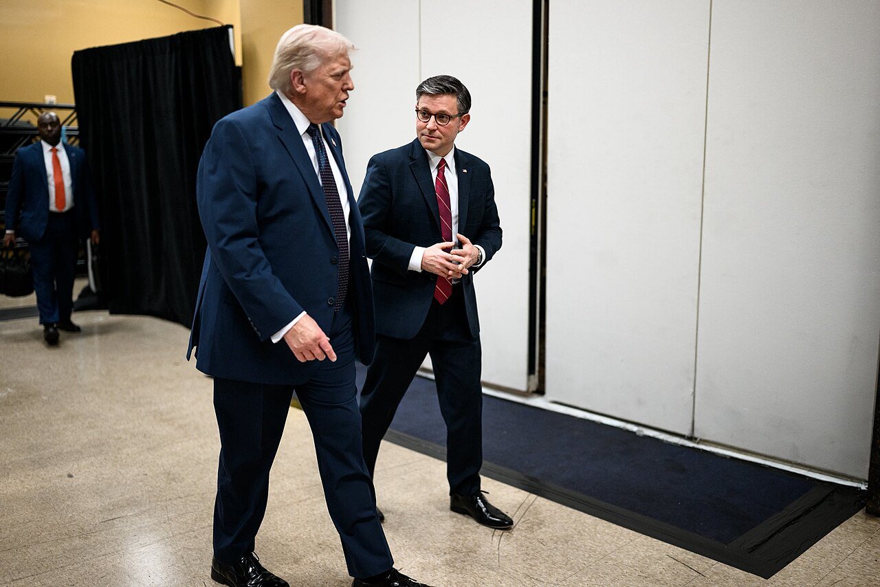 Donald Trump caminha ao lado do presidente da Câmara dos Representantes, Mike Johnson, nos bastidores de um evento