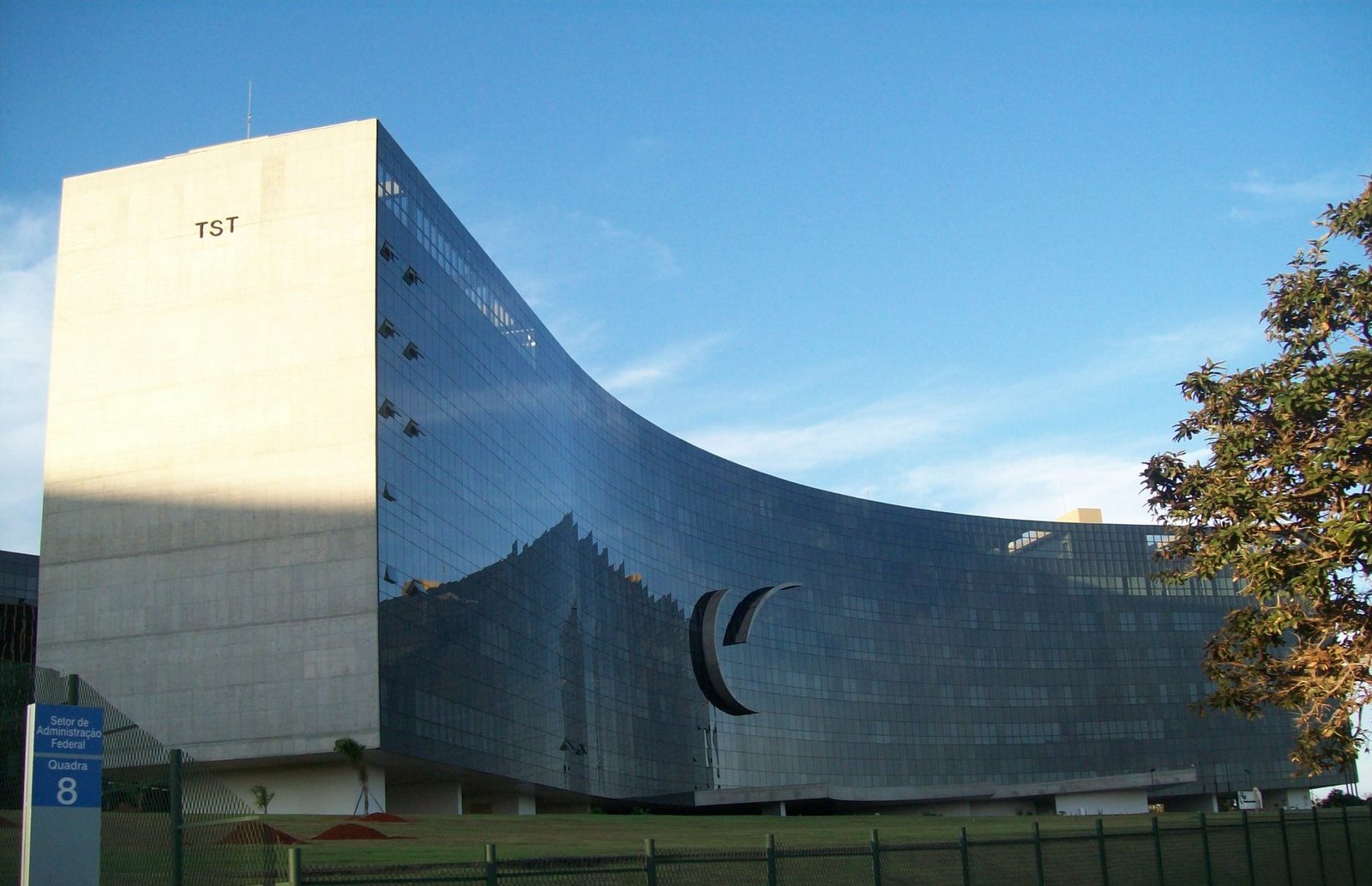 Fachada curva do edifício do Tribunal Superior do Trabalho, em Brasília, com a sigla TST na lateral