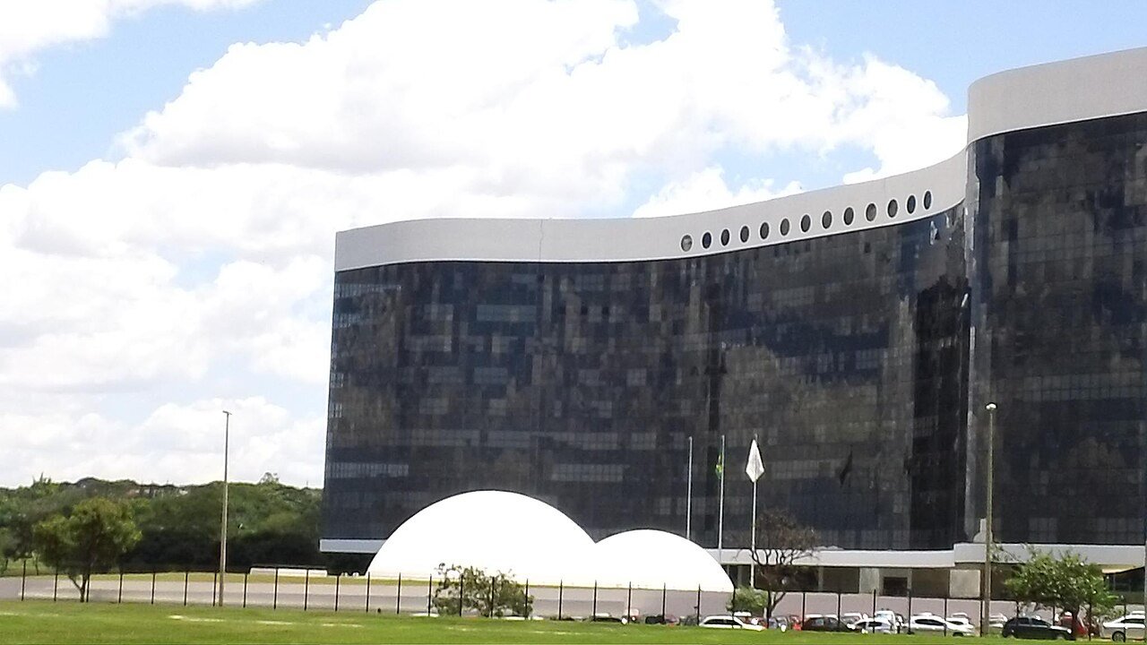 Sede do Tribunal Superior Eleitoral, em Brasília, com fachada espelhada e bandeira do Brasil hasteada
