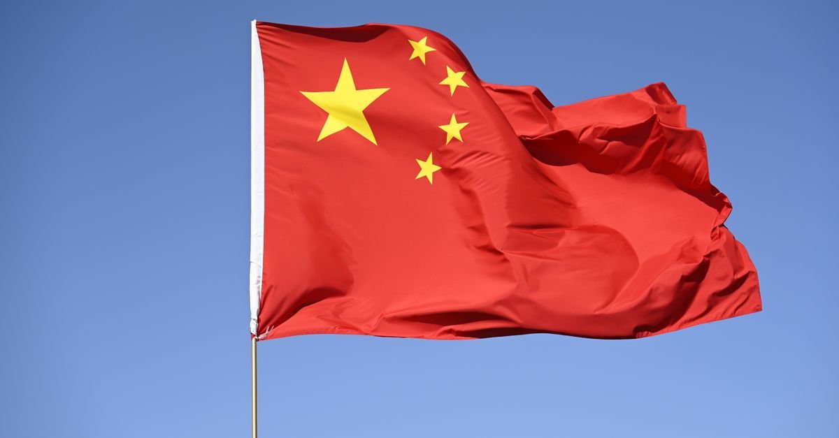 Bandeira nacional da China hasteada contra o céu azul