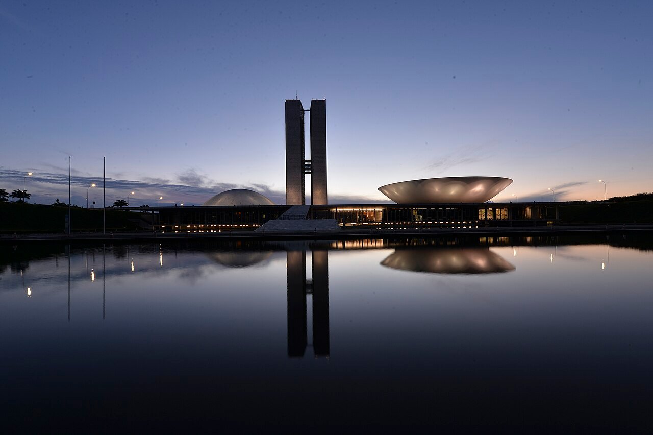 Congresso Nacional ao anoitecer, com as duas torres e as cúpulas refletidas no espelho d'água